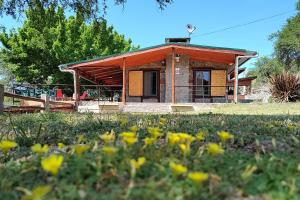 a small house with a field of flowers in front of it at Vado Biguá in Valle Hermoso