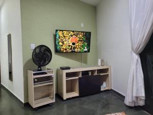 a living room with a flat screen tv on a wall at Apartamento Relax Enseada Bertioga SP in Bertioga