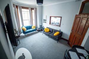 a living room with two blue couches and yellow pillows at 1 BDR Apartment By Eason Stays Short Lets & Serviced Accommodation Lowestoft With Free parking in Lowestoft