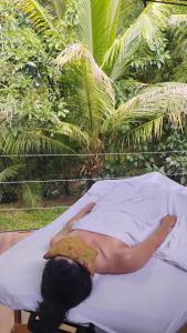 a woman is laying on a bed in aitures at Zen Den Nature Retreat on a River in Rincon