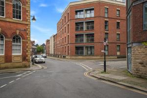 an empty street next to a brick building at 2 BR Apt By Eason Stays Short Lets & Serviced Accommodation Kelham Island Sheffield With Free Wifi in Midland