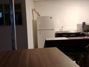 eine Küche mit einem weißen Kühlschrank und einem Tisch in der Unterkunft Habitaciones Clásica en lo mejor de SS city in San Salvador