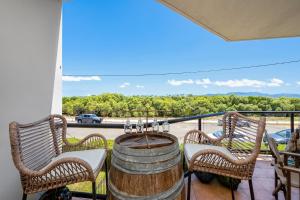 a balcony with two chairs and a barrel at Breezes, Ocean and an Uncompromised Lifestyle in Belgian Gardens