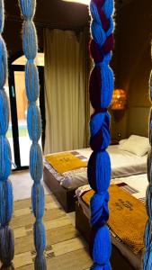 a room with two beds with blue strands of yarn at Wazidi Resort in Siwa