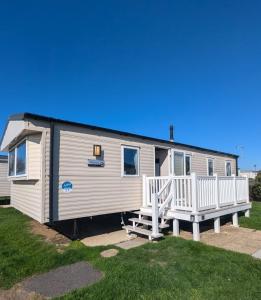 a white caravan with a porch and two chairs at Pet friendly holiday home located at Littlesea Holiday Park, In Weymouth, Dorset in Wyke Regis