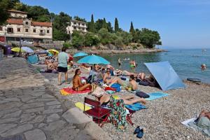 a group of people sitting on a beach at Apartment Opric 7695a in Opric