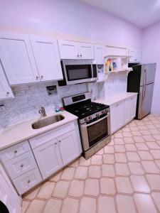 a kitchen with white cabinets and a stove and a sink at Amazing private Room in Glendale +27 photos