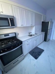 a kitchen with white cabinets and a stove and refrigerator at Amazing private Room in Glendale +9 photos
