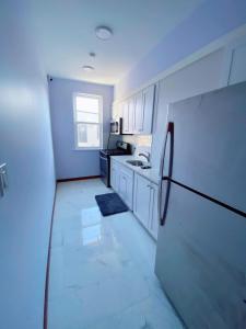 a kitchen with white cabinets and a black refrigerator at Amazing private Room in Glendale