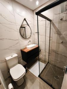 a bathroom with a toilet and a sink and a mirror at Refúgio cercado pela natureza em Pomerode in Pomerode