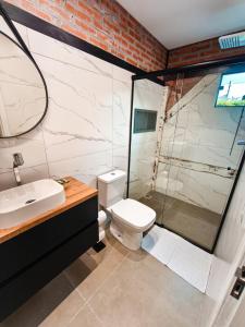 a bathroom with a shower and a toilet and a sink at Refúgio cercado pela natureza em Pomerode in Pomerode +27 photos