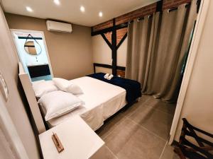 a small bedroom with a bed with white pillows at Refúgio cercado pela natureza em Pomerode in Pomerode