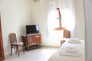 a bedroom with a bed and a tv and a window at Alta Gracia Hotel Boutique in Alta Gracia