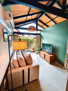 a living room with a couch and a television at Refúgio cercado pela natureza em Pomerode in Pomerode