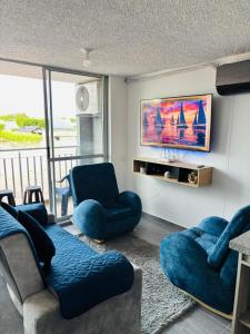 un salon avec deux chaises bleues et une télévision dans l'établissement Loft Vacaciional, à Ricaurte 17 autres photos
