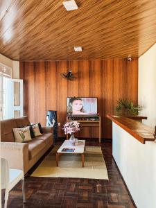 a living room with a couch and a tv at Pousada da Orla in Itacaré +36 photos