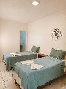 two beds sitting next to each other in a room at Pousada da Orla in Itacaré