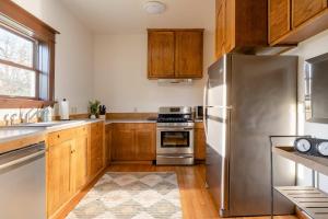 une cuisine avec un réfrigérateur en acier inoxydable et des armoires en bois dans l'établissement Stay Portland - 4BR Historic Soul District Remodel w Detached Unit, à Piedmont 30 autres photos