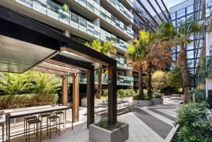 a courtyard with tables and chairs in a building at VAQUAY Belladonna In Abbotsford in Melbourne