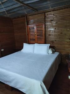 een slaapkamer met een groot bed met witte kussens bij hotel san rafael in Santa Marta
