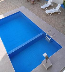 an overhead view of a blue swimming pool with two chairs at A M Hotel in São Luís