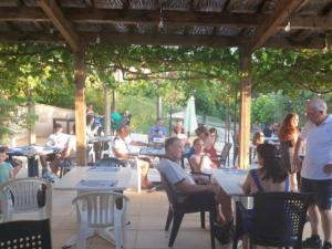 a group of people sitting at tables on a patio at Mobil home confortable avec terrasse, espace pour 4 personnes - API-1-52-426 in Salles