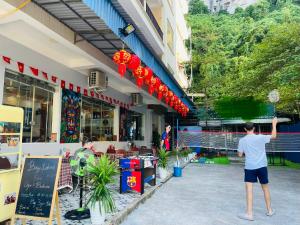 a man standing in front of a building at CATBA PANDORA Hotel & Travel in Cat Ba