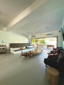 a living room with people sitting on couches and tables at Port Douglas Backpackers in Port Douglas