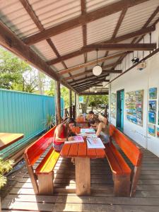 three girls sitting at a picnic table on a deck at Port Douglas Backpackers in Port Douglas