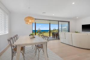 Un comedor y una sala de estar con mesa y sillas. en 13 Jordan, en Bonny Hills