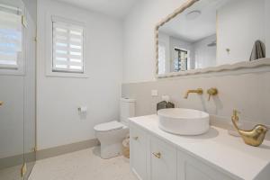 Un baño con lavabo, inodoro y espejo. en 13 Jordan, en Bonny Hills 19 fotos más