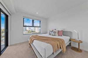 a white bedroom with a bed and a window at Verve on Cotton Tree managed by Sunny Coast Escapes in Maroochydore +25 photos