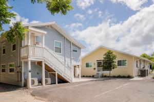 a house with a staircase in a parking lot at Cozy Coastal Cottages of Dunedin in Dunedin