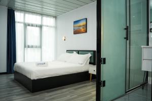 a bedroom with a bed and a glass door at Hotel Laimoa in Apia