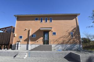 ein Backsteingebäude mit einer Tür und einer Treppe darauf in der Unterkunft レイクウエスト4-711 in Wada + 3 Fotos