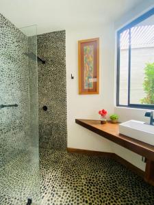 a bathroom with a glass shower and a sink at casaNorte paraíso norteño mirador de Ballenas in Canoas De Punta Sal