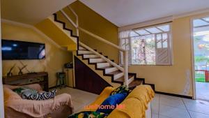 ein Wohnzimmer mit Treppe und Couch in der Unterkunft Casa em Salvador Praia do Flamengo jardim e paz in Salvador