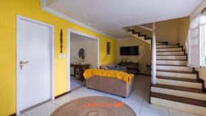 ein Wohnzimmer mit einer Treppe und gelben Wänden in der Unterkunft Casa em Salvador Praia do Flamengo jardim e paz in Salvador