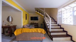Zimmer mit einer Treppe, einem Bett und einem Tisch in der Unterkunft Casa em Salvador Praia do Flamengo jardim e paz in Salvador