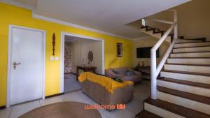 ein Wohnzimmer mit einer Couch und einer Treppe in der Unterkunft Casa em Salvador Praia do Flamengo jardim e paz in Salvador + 19 Fotos