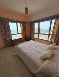 een slaapkamer met een groot bed en 2 grote ramen bij Miramar Vista al Mar in Miramar