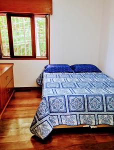 a bedroom with a bed and two windows at Quarto próximo Consulado Americano e metrô Borba Gato in São Paulo