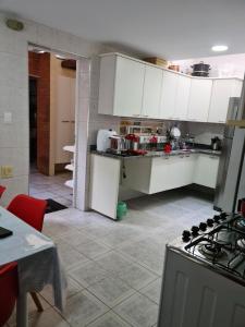a kitchen with white cabinets and a stove top oven at Quarto próximo Consulado Americano e metrô Borba Gato in São Paulo