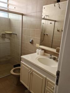 a bathroom with a sink and a mirror and a toilet at Quarto próximo Consulado Americano e metrô Borba Gato in São Paulo