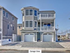 a large house with two garage doors in a driveway at Oceanside Single Family Brant Beach Beach Badges Rooftop Deck Wifi Private Yard Washer & Dryer in Beach Haven Crest