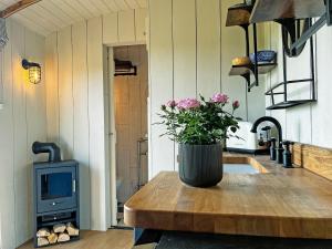a kitchen with a table with a vase of flowers on it at The Carriage - Uk48947 in Shirland