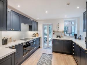 a kitchen with black cabinets and white counter tops at Warrington House-Uk48465 in Thornton Dale
