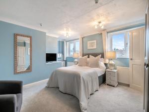 a bedroom with a bed with blue walls and a mirror at Warrington House-Uk48465 in Thornton Dale +12 photos