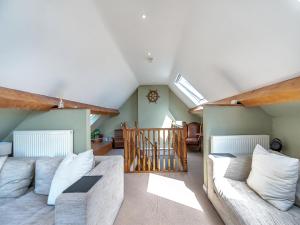 ein Wohnzimmer mit einer Couch und einer Treppe in der Unterkunft Chapel Bay Cottage in Angle