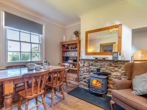 ein Esszimmer mit Tisch und Kamin in der Unterkunft Chapel Bay Cottage in Angle